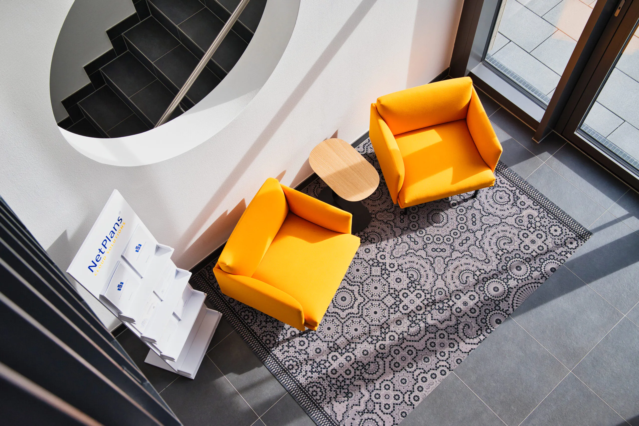Vogelperspektive der Sitzecke im Treppenhaus mit orangenen Sesseln